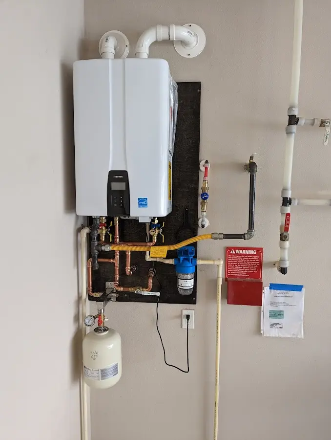 Professional plumber installing copper piping in a James City home